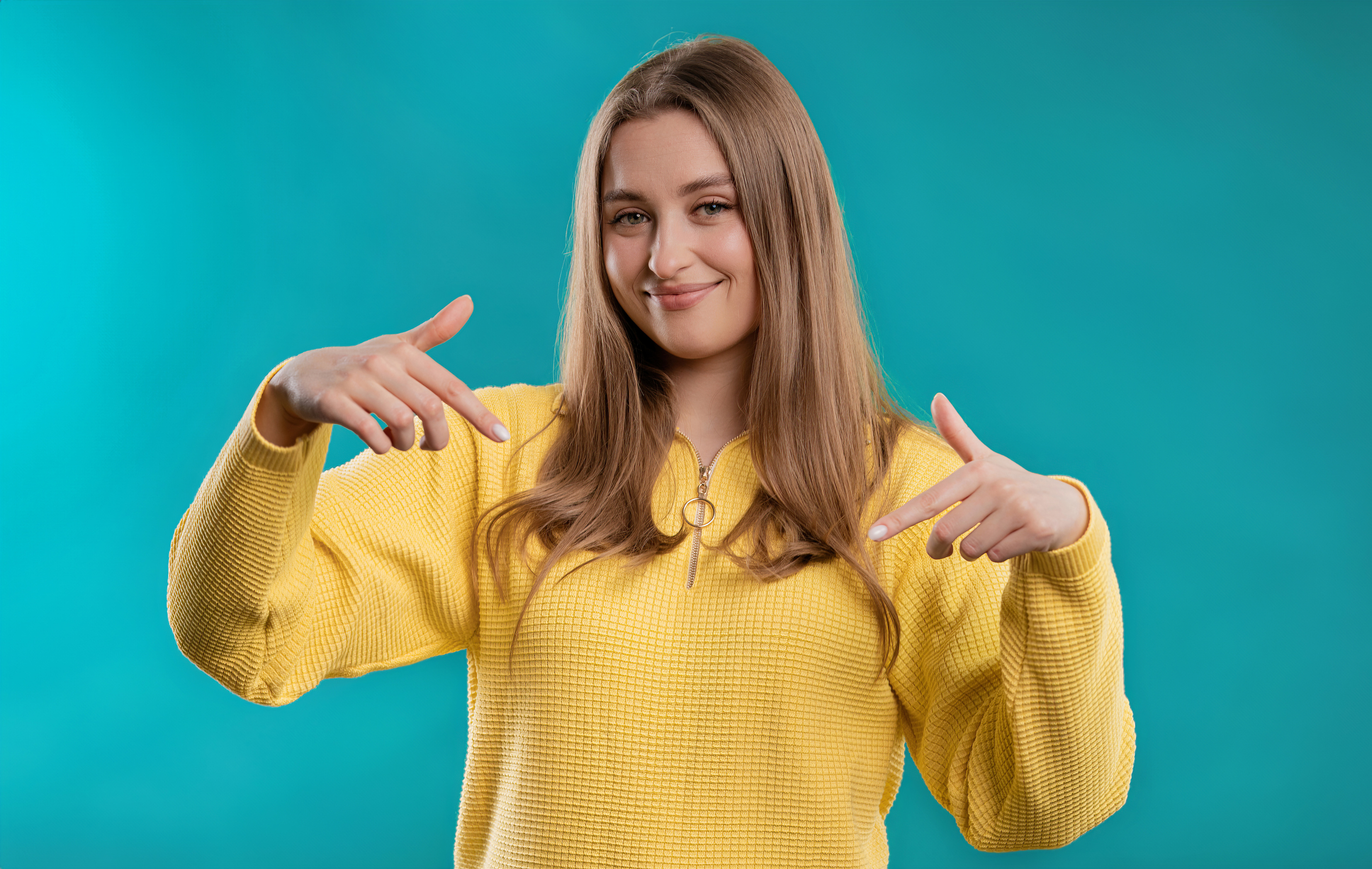 Pretty woman pointing down to advertising area. Blue background. Click subscribe